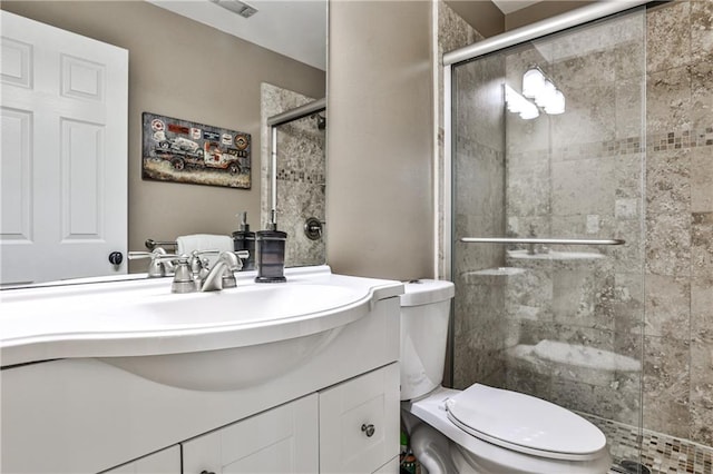 full bath with vanity, a stall shower, and toilet