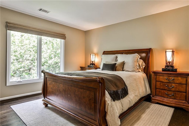 bedroom with baseboards, visible vents, and dark wood-style floors