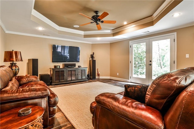 living area featuring crown molding, a ceiling fan, wood finished floors, and a raised ceiling