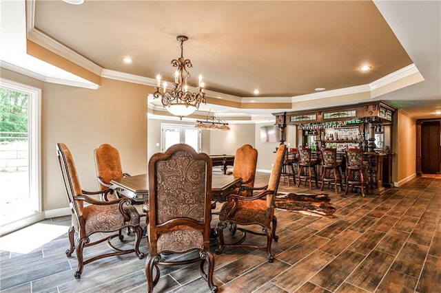 dining room featuring crown molding, a tray ceiling, a chandelier, and baseboards