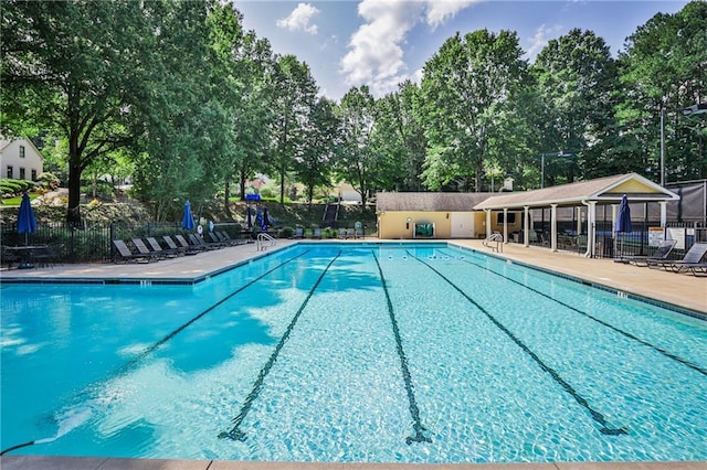 community pool featuring fence and a patio