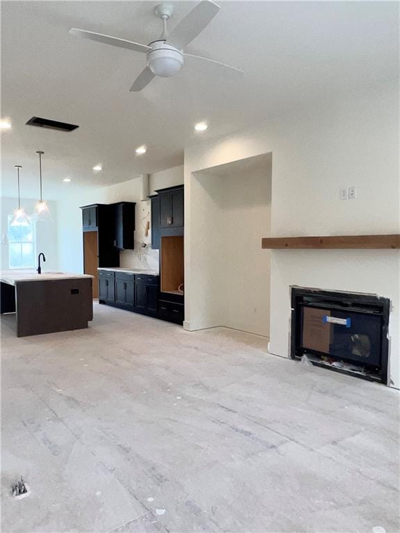 unfurnished living room with ceiling fan and sink