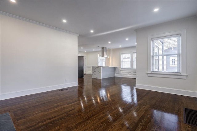 unfurnished living room with recessed lighting, visible vents, dark wood-style floors, and ornamental molding