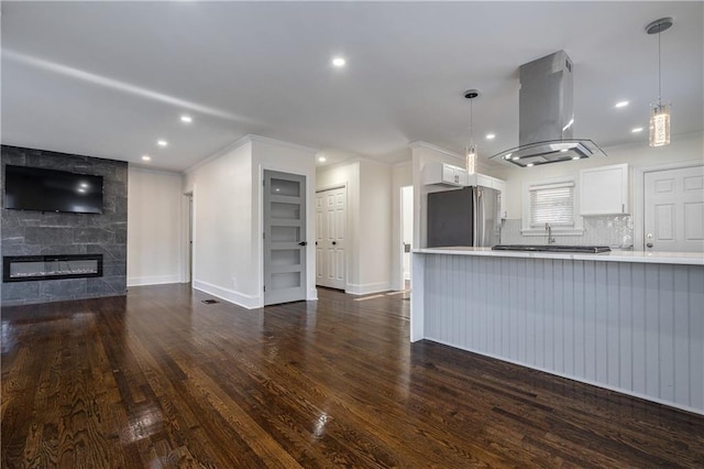 unfurnished living room with a large fireplace, baseboards, ornamental molding, recessed lighting, and dark wood-style flooring