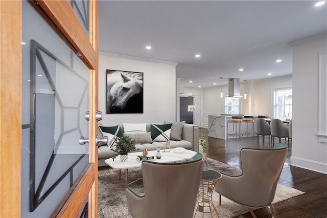 living area featuring recessed lighting, wood finished floors, baseboards, and ornamental molding