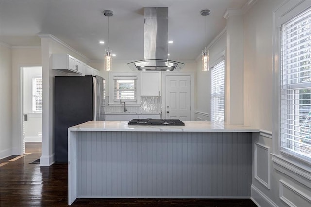 kitchen featuring island exhaust hood, gas cooktop, freestanding refrigerator, white cabinets, and crown molding