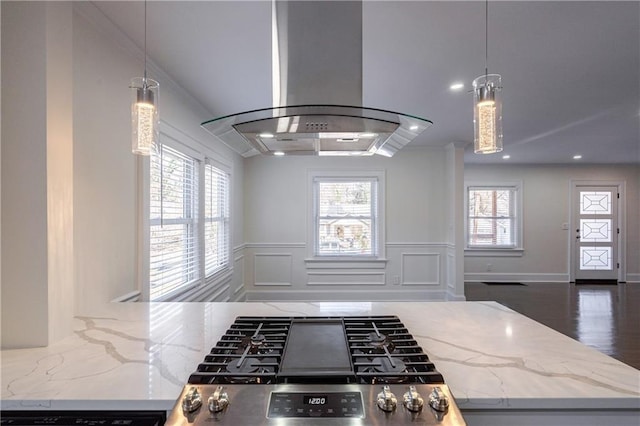 kitchen with stainless steel gas range oven, crown molding, open floor plan, island range hood, and a decorative wall