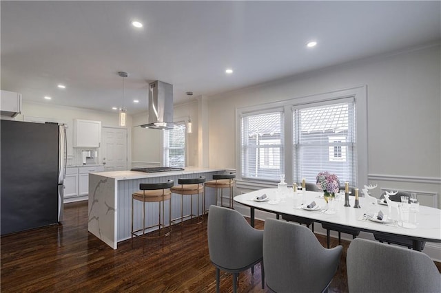 kitchen with dark wood finished floors, white cabinetry, appliances with stainless steel finishes, island range hood, and light countertops