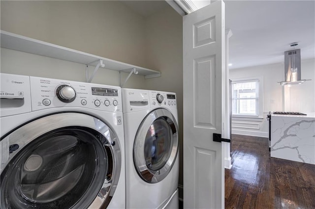 laundry area featuring wood finished floors, laundry area, and washing machine and clothes dryer