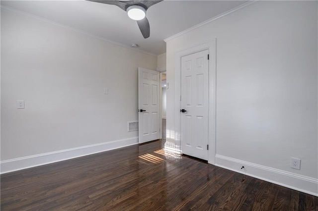 unfurnished bedroom with visible vents, baseboards, wood finished floors, and crown molding