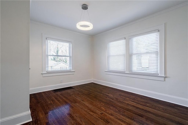 unfurnished room with dark wood-style floors, visible vents, baseboards, and ornamental molding