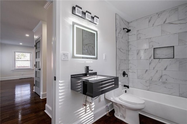 bathroom with tub / shower combination, baseboards, toilet, and wood finished floors