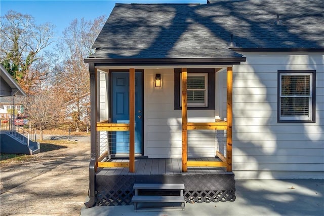 doorway to property featuring roof with shingles