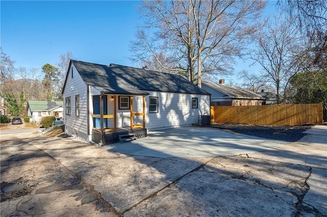 view of front of home featuring central AC unit and fence