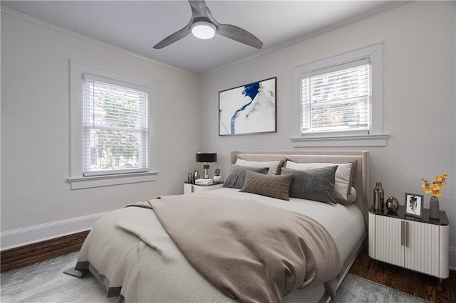 bedroom with wood finished floors, baseboards, multiple windows, and ornamental molding