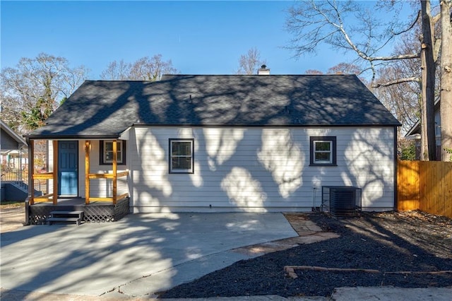 back of property featuring a patio, roof with shingles, central AC, and fence