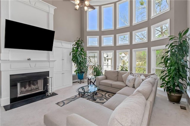 5810 Old Mill Trce, Lithonia, GA 30038 - living room with ceiling fan, a high ceiling, light carpet, and a fireplace with flush hearth