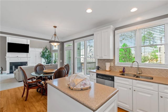 5810 Old Mill Trce, Lithonia, GA 30038 - kitchen with stainless steel dishwasher, a sink, a center island, a fireplace, and white cabinetry