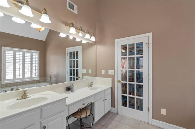 5810 Old Mill Trce, Lithonia, GA 30038 - bathroom featuring double vanity, tile patterned flooring, lofted ceiling, a bath, and baseboards