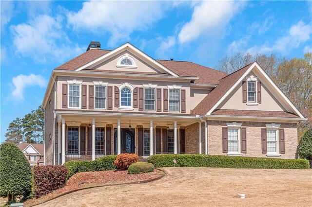 5810 Old Mill Trce, Lithonia, GA 30038 - colonial house with stucco siding, a chimney, covered porch, brick siding, and a shingled roof
