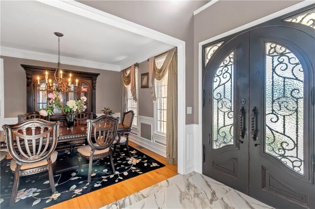 5810 Old Mill Trce, Lithonia, GA 30038 - foyer featuring french doors, a chandelier, marble look tile flooring, a wainscoted wall, and ornamental molding