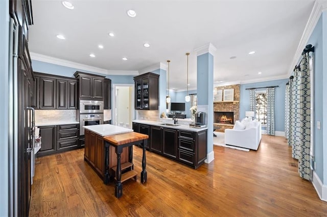 kitchen with a center island, refrigerator, oven, decorative backsplash, and dark brown cabinets