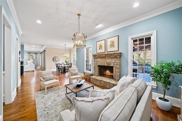 living room featuring a stone fireplace, crown molding, and wood-type flooring