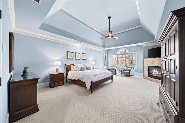 bedroom with light colored carpet, ceiling fan, and a raised ceiling