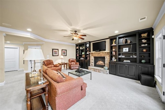 living room featuring ceiling fan, a stone fireplace, ornamental molding, and light carpet