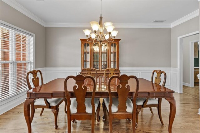 9507 Greens Mill Ct, Loganville, GA 30052 - dining area featuring a chandelier, light wood-style floors, ornamental molding, and wainscoting