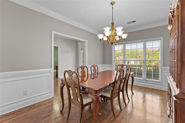 9507 Greens Mill Ct, Loganville, GA 30052 - dining space featuring a chandelier, ornamental molding, wood finished floors, and a wainscoted wall