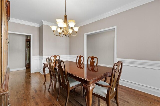 9507 Greens Mill Ct, Loganville, GA 30052 - dining space with a chandelier, crown molding, wood finished floors, and a wainscoted wall