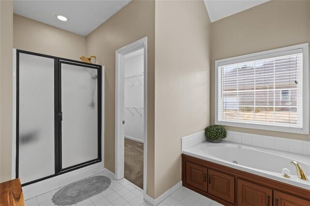 9507 Greens Mill Ct, Loganville, GA 30052 - bathroom with a stall shower, a bath, a spacious closet, tile patterned floors, and baseboards