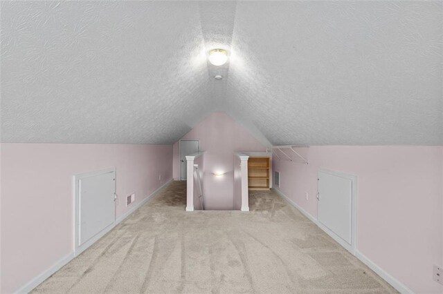 9507 Greens Mill Ct, Loganville, GA 30052 - bonus room featuring carpet flooring, a textured ceiling, lofted ceiling, and baseboards