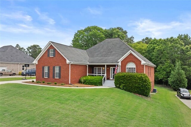 9507 Greens Mill Ct, Loganville, GA 30052 - traditional-style house with brick siding, a front lawn, covered porch, and a shingled roof