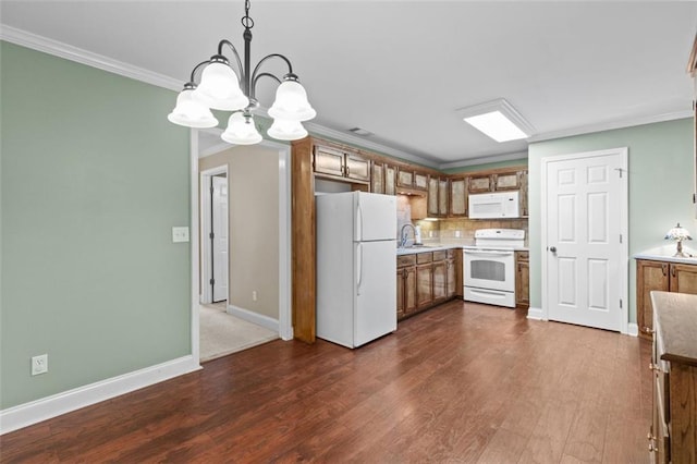 9507 Greens Mill Ct, Loganville, GA 30052 - kitchen featuring white appliances, a sink, brown cabinetry, a chandelier, and ornamental molding