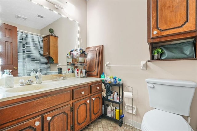 bathroom featuring vanity, curtained shower, and toilet