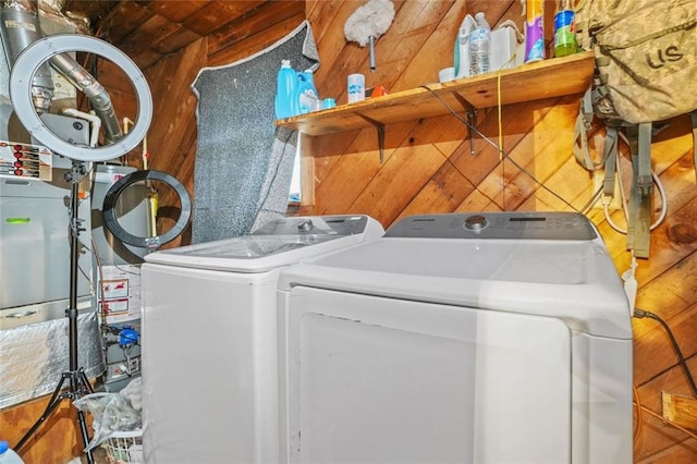 laundry area featuring washer and dryer and wood walls