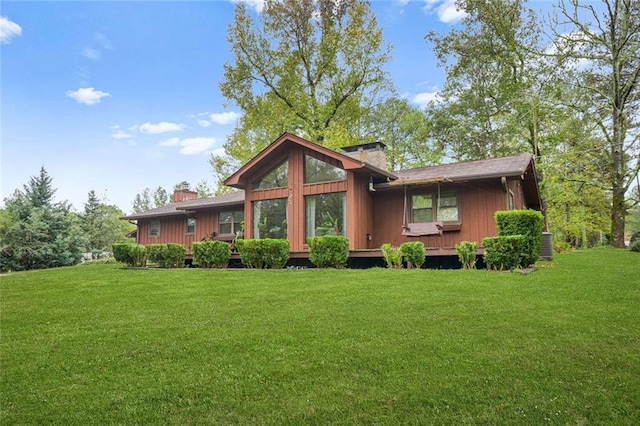 rear view of house featuring a yard and central air condition unit