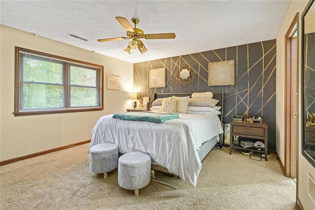 bedroom with ceiling fan, carpet, and a textured ceiling