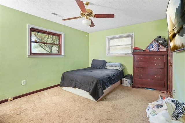 bedroom featuring ceiling fan, carpet, and a textured ceiling