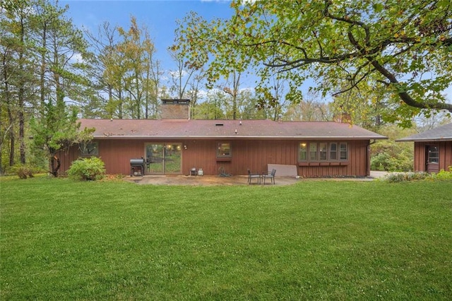 back of property with a yard and a patio