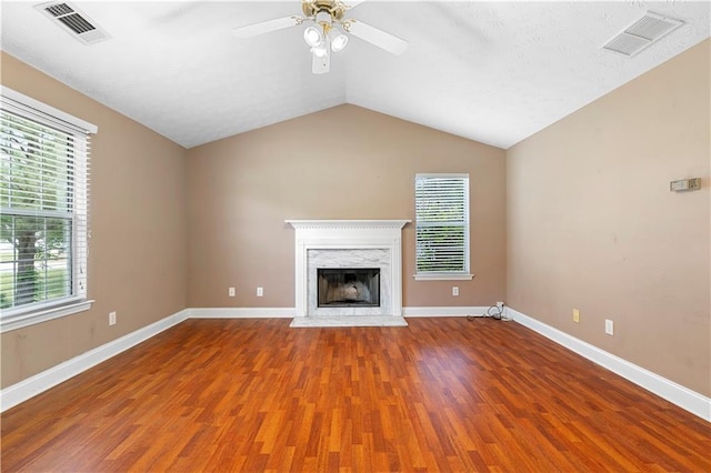 90 Cypress Dr, Covington, GA 30016 - unfurnished living room with wood finished floors, a ceiling fan, plenty of natural light, a premium fireplace, and vaulted ceiling