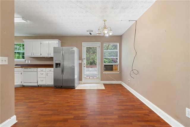 90 Cypress Dr, Covington, GA 30016 - kitchen with stainless steel fridge, dishwasher, dark wood finished floors, a chandelier, and plenty of natural light