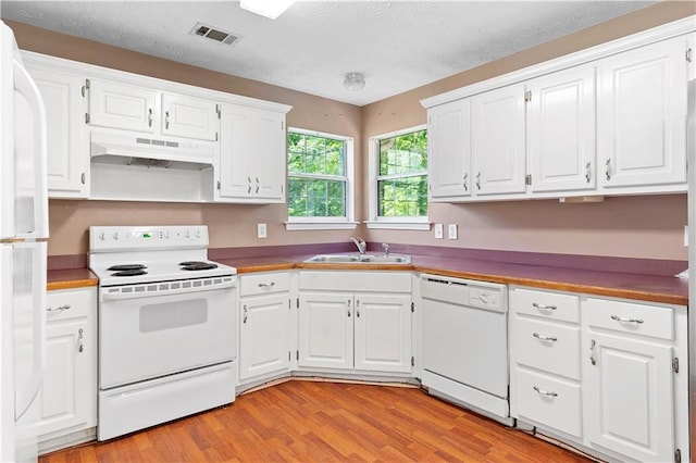 90 Cypress Dr, Covington, GA 30016 - kitchen featuring white appliances, under cabinet range hood, a sink, light wood-type flooring, and white cabinets