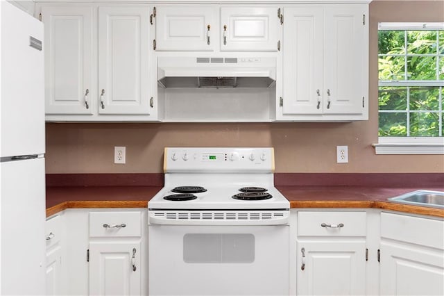 90 Cypress Dr, Covington, GA 30016 - kitchen featuring under cabinet range hood, white appliances, dark countertops, and white cabinets