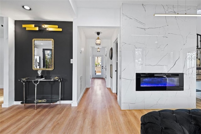 hallway featuring visible vents, baseboards, and wood finished floors