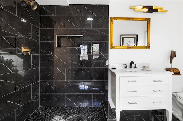 full bath featuring tiled shower, toilet, and vanity