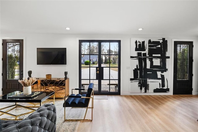 living room with recessed lighting, wood finished floors, and french doors