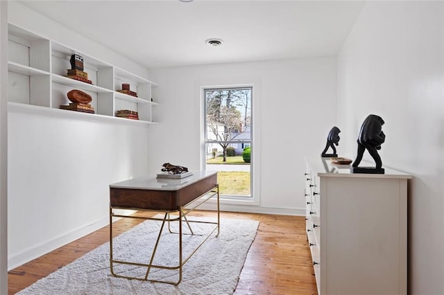 office with light wood-type flooring, visible vents, and baseboards